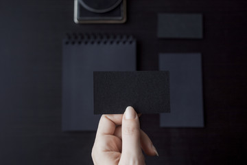 Set of black mockups on dark background,  female hand holding a