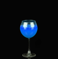 Blue alcoholic cocktail on the black background