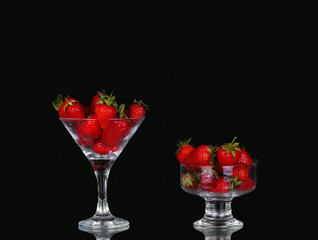 collage Strawberries in glass on black background