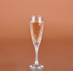 a glass of champagne on a beige background