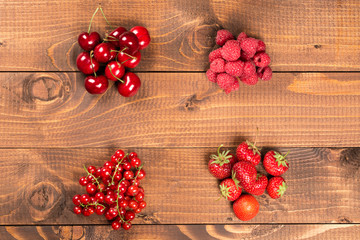 Fototapeta na wymiar Collection of cherries, strawberries, red currants, raspberries on wood background