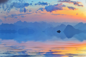 Calm water and far summer mountains in the evening