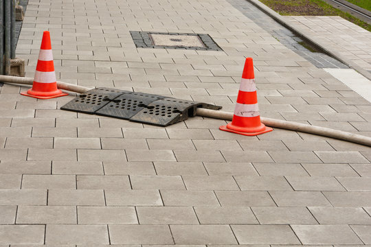 Zwei Pilonen sichern eine Schlauchbr&uuml;cke auf einem Fussweg