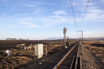 Fototapeta na wymiar Railway Lines Running Between Burnt Farm Fields