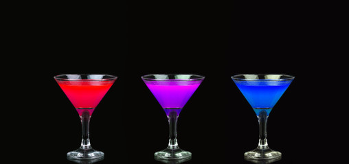 Cosmopolitan cocktail in nice red, purple and blue in front of a black background