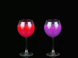 Cosmopolitan cocktail in nice red and purple colors in front of a black background