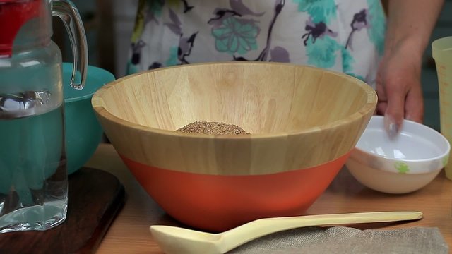 Female pour the linseed and cumin in the bowl