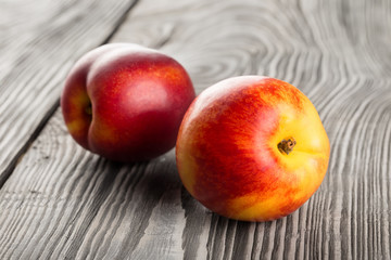 Two nectarines on wooden table
