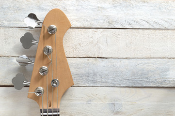 Electric Bass Guitar, against a white wooden background. Editor's view. Wide copy space for editor's text.