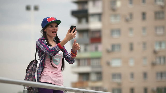 Девушка фотографируется на смартфон