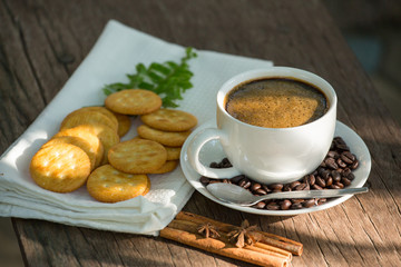 Cup of coffee on a wooden board and biscuits