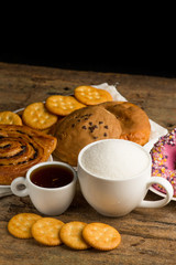Cup of coffee on a wooden board and biscuits