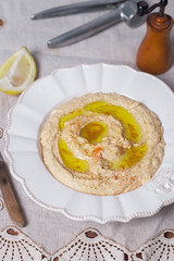 Appetizer creamy hummus tasty traditional food with tahini paste, olive oil, paprika and parsley in rustic plate on vintage  background