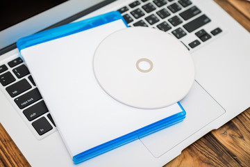 Blank compact disc with cover on laptop keyboard