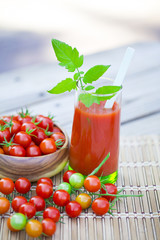 Cherry tomatoes and a glass of tomato juice.