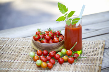 Cherry tomatoes and a glass of tomato juice.