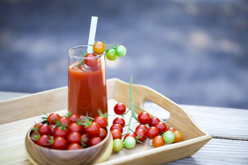 Cherry tomatoes and a glass of tomato juice.