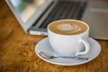 laptop with coffee cup on old wooden table ( Filtered image proc