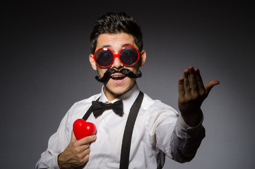 Young man with false moustache isolated on gray