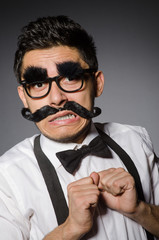 Young man with false moustache isolated on gray