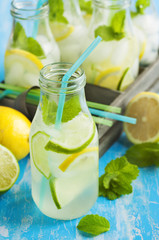 Lemonade in glass bottle with ice and mint