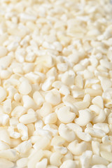 food background of raw white corn grits, tilt shift lens