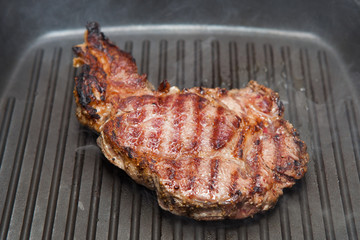 frying beef steak on a ribbed grill pan