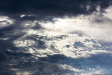 dark gray big cloud before raining in the evening, sun behind