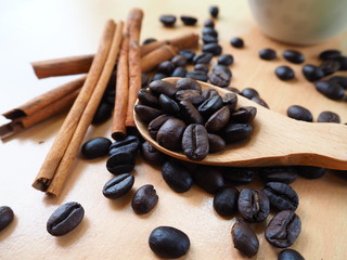 coffee beans and cinnamon sticks on wood table