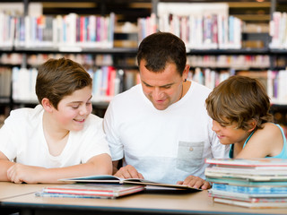 Fototapeta na wymiar Father with sons in library