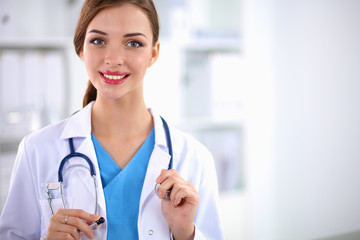 Woman doctor is standing near window 