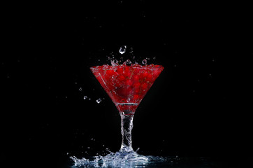 Water with red currants on a black background