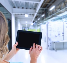 Composite image of rear view of woman using tablet pc