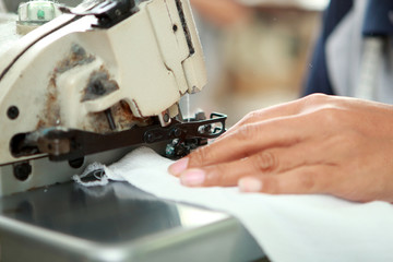 hands of worker and industrial sewing machine