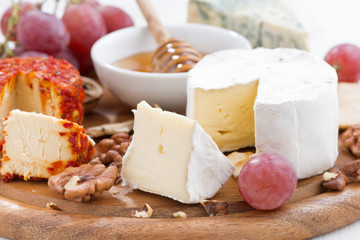 cheeses and snacks on a board, close-up