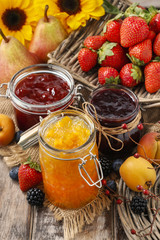Peach, blueberry and strawberry jams in glass jars