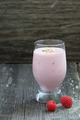 milkshake with raspberries on a grey wooden background