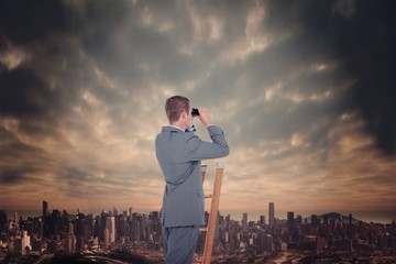 Fototapeta na wymiar Composite image of businessman looking on a ladder