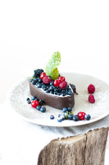 Melting ice cream with chocolate glaze and garnished with fresh berries.