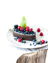 Melting ice cream with chocolate glaze and garnished with fresh berries.
