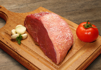Raw meat selection on wooden cutting board with knife