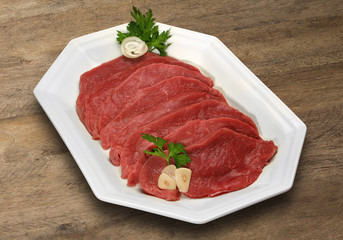 Raw meat selection on wooden cutting board with knife