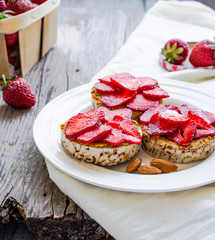 crispbread with peanut butter and fresh strawberries on a  round