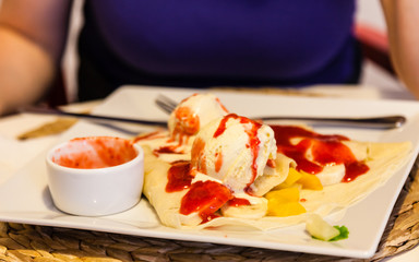 Pancake with ice cream and strawberry sauce