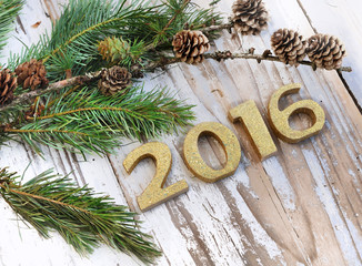 2016 en chiffres doré avec branches de sapin sur bois blanc 