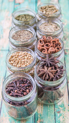 Herbs and spices on in mason jar over weathered wooden background