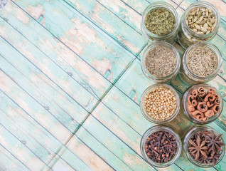 Herbs and spices on in mason jar over weathered wooden background