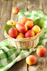 Fresh apricots in basket on a grey wooden background