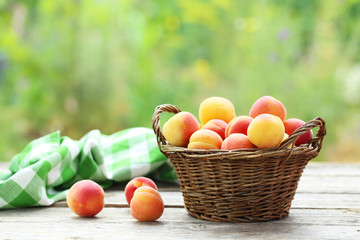 Fresh apricots in basket on a grey wooden background, ourdoors