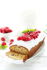 Raspberry cake on plate on white wooden background